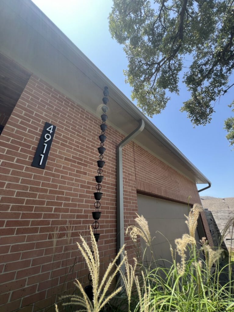 Seamless gutter with rain chain downspout on modern brick home