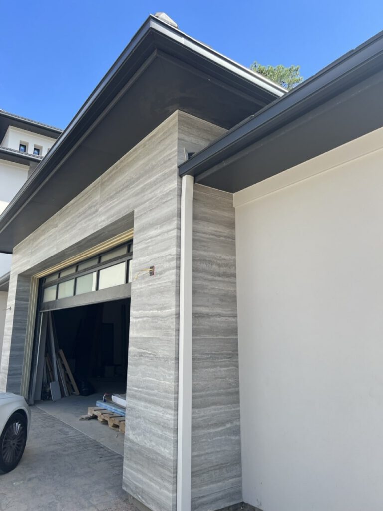 Seamless gutters on new build with stone and stucco exterior